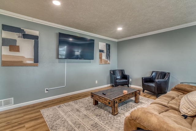 living room featuring hardwood / wood-style flooring, crown molding, and a textured ceiling