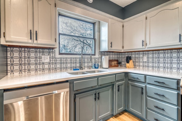 kitchen with backsplash, light wood-type flooring, white cabinets, and stainless steel dishwasher