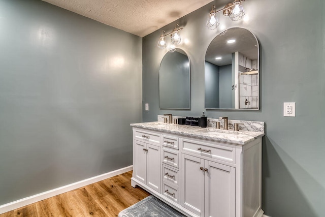 bathroom featuring hardwood / wood-style flooring, vanity, and a textured ceiling