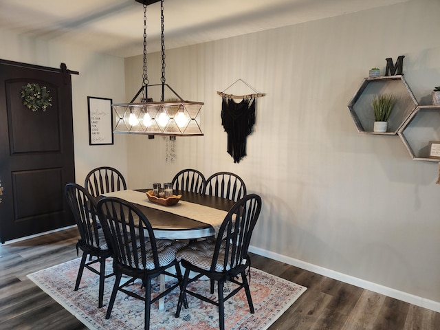 dining area featuring a barn door and dark hardwood / wood-style flooring