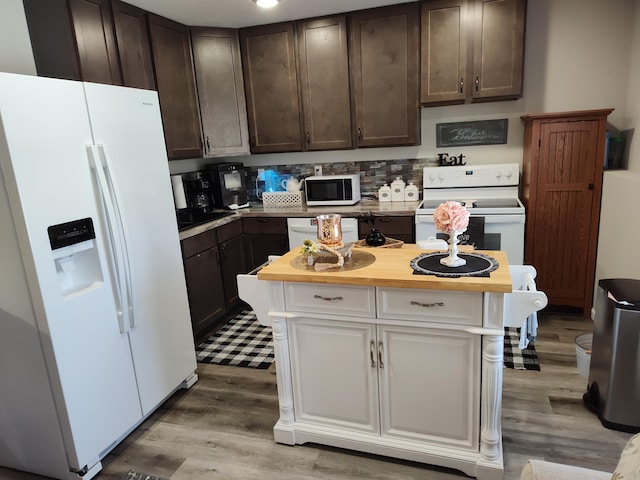 kitchen with dark brown cabinets, light wood-type flooring, and white appliances