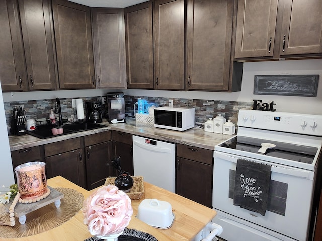 kitchen with dark brown cabinets, sink, and white appliances