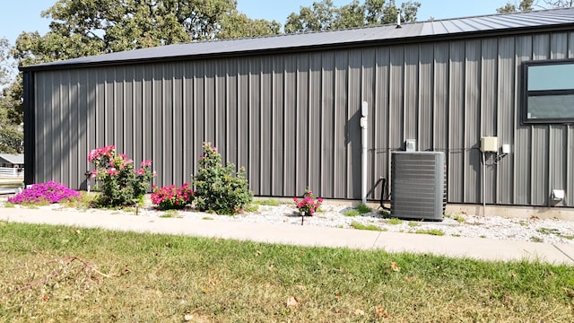 view of outbuilding featuring a yard and central AC