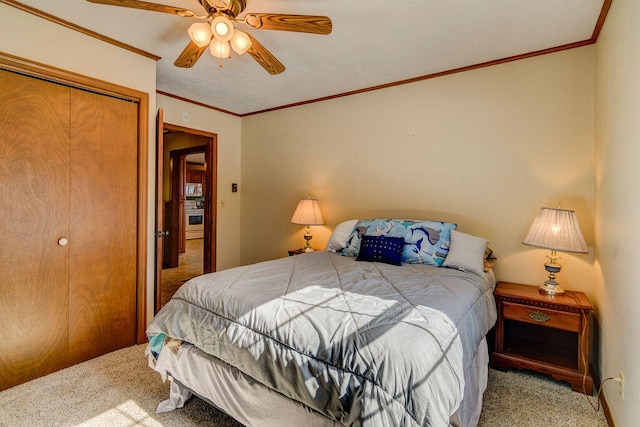 carpeted bedroom with a closet, ornamental molding, and ceiling fan