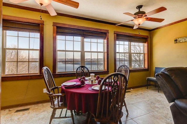 dining area with ornamental molding, a water view, ceiling fan, and light tile patterned floors