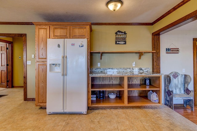 kitchen with crown molding, a textured ceiling, and white refrigerator with ice dispenser