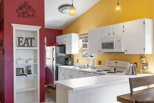 kitchen featuring white appliances, hanging light fixtures, and white cabinetry