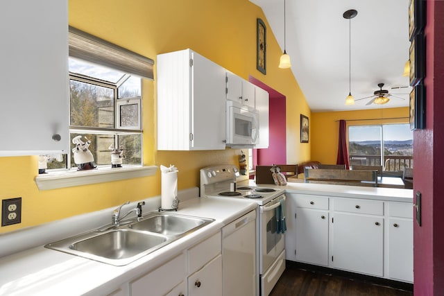 kitchen with white cabinets, white appliances, sink, vaulted ceiling, and decorative light fixtures