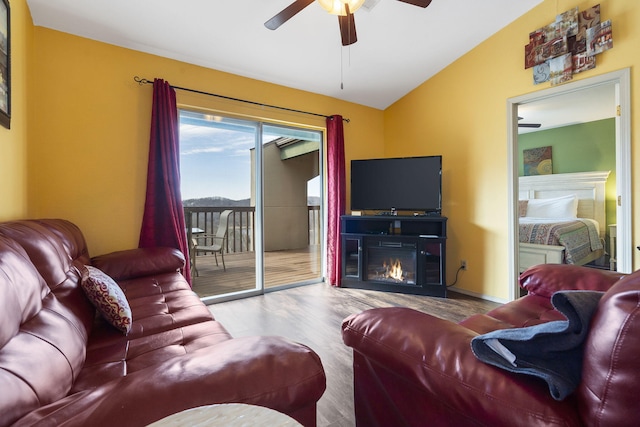 living room featuring lofted ceiling, ceiling fan, and light hardwood / wood-style flooring