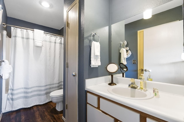 bathroom with a shower with curtain, hardwood / wood-style floors, vanity, and toilet