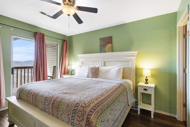 bedroom with dark hardwood / wood-style flooring, a mountain view, and ceiling fan