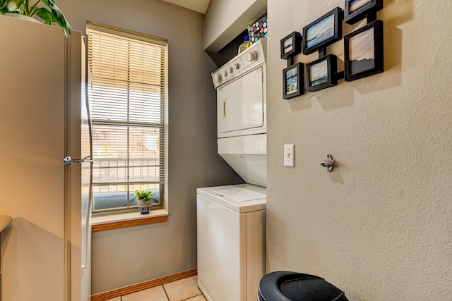 laundry room featuring light tile patterned flooring and stacked washer / dryer