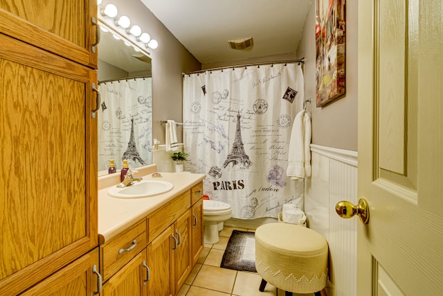 bathroom with walk in shower, vanity, toilet, and tile patterned floors