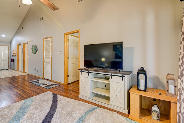 living room featuring ceiling fan, hardwood / wood-style floors, and high vaulted ceiling