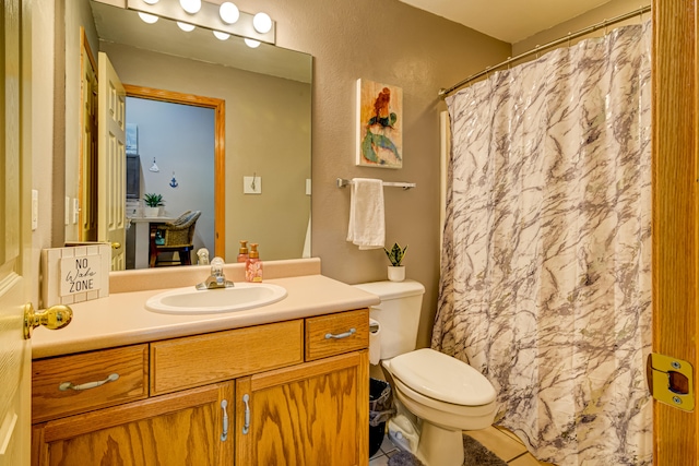 bathroom with a shower with shower curtain, vanity, toilet, and tile patterned floors