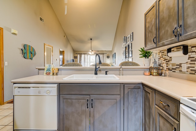 kitchen with ceiling fan, dark brown cabinetry, white appliances, sink, and light tile patterned floors