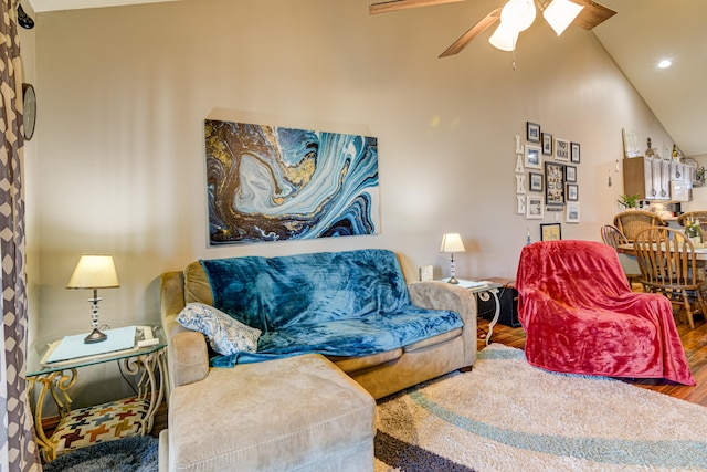 living room featuring ceiling fan, hardwood / wood-style floors, and vaulted ceiling