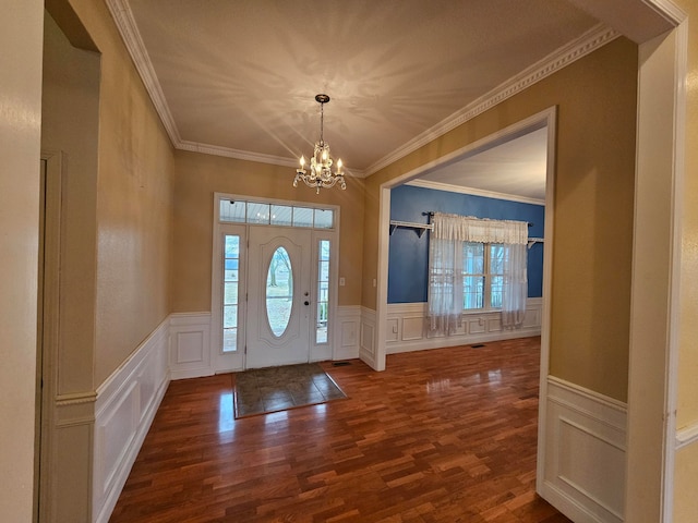 foyer with a notable chandelier, crown molding, and dark wood-type flooring