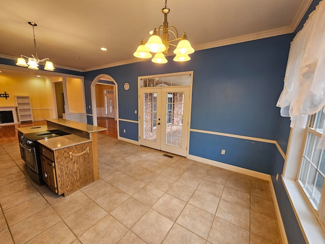 kitchen featuring light tile patterned flooring, a chandelier, pendant lighting, crown molding, and electric range