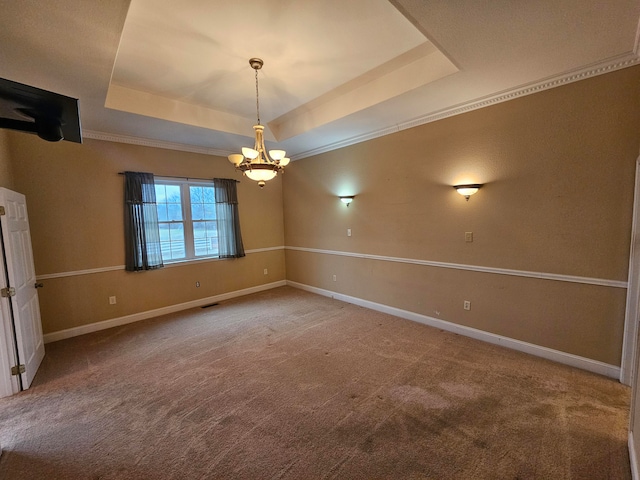 spare room with a notable chandelier, crown molding, carpet, and a raised ceiling