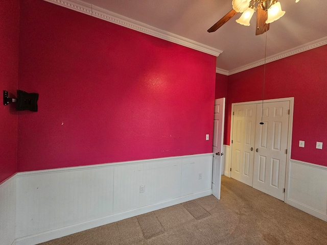 carpeted spare room with ornamental molding and ceiling fan