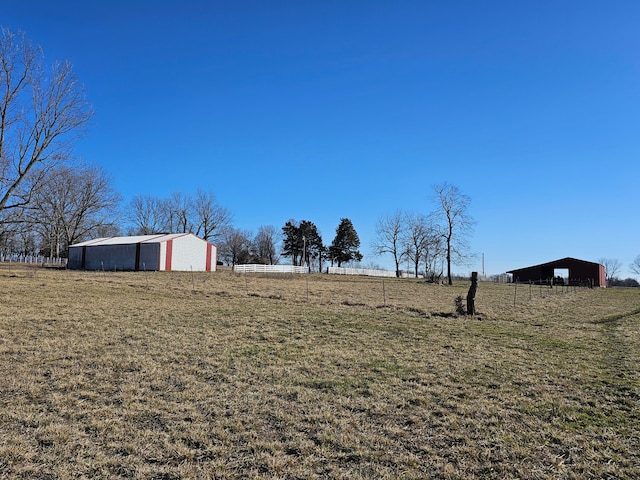 view of yard with a rural view and an outbuilding