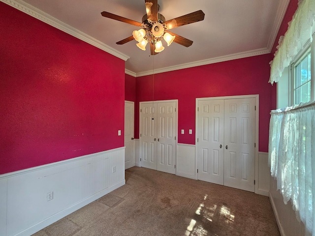 unfurnished bedroom featuring ornamental molding, carpet, and ceiling fan