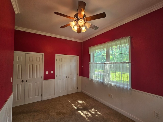 carpeted empty room featuring ornamental molding and ceiling fan