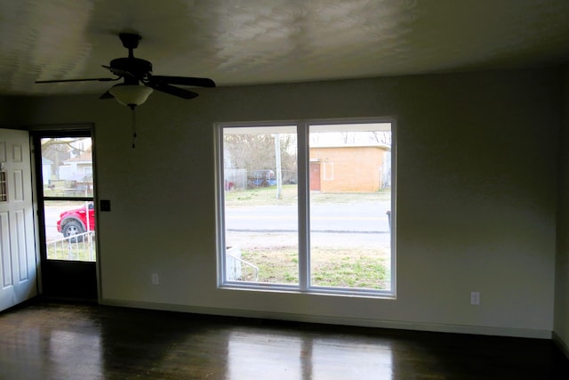 unfurnished room with ceiling fan and dark hardwood / wood-style floors