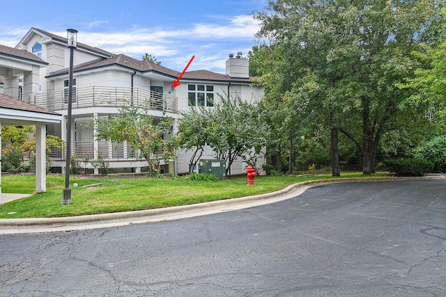 view of front of house featuring a front yard and a balcony