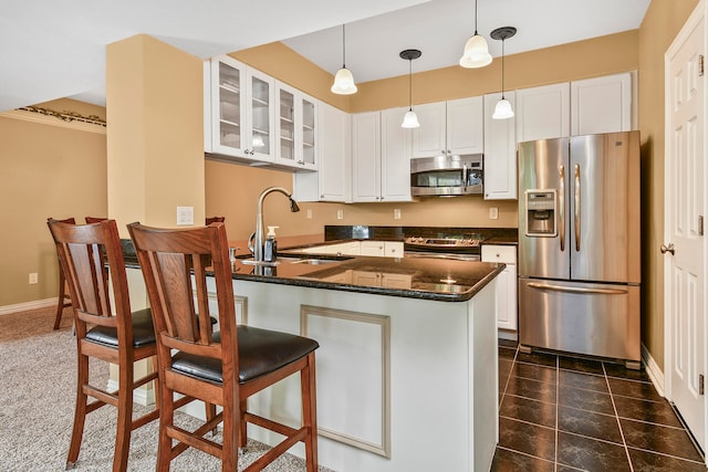 kitchen featuring pendant lighting, sink, white cabinetry, appliances with stainless steel finishes, and a kitchen breakfast bar