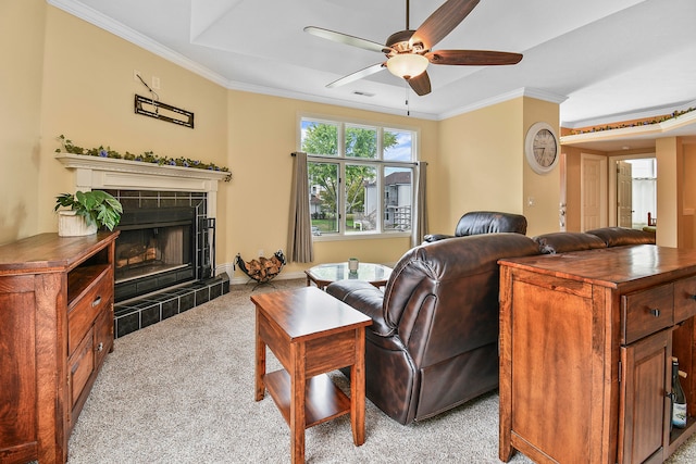 living room with light carpet, crown molding, ceiling fan, and a tile fireplace