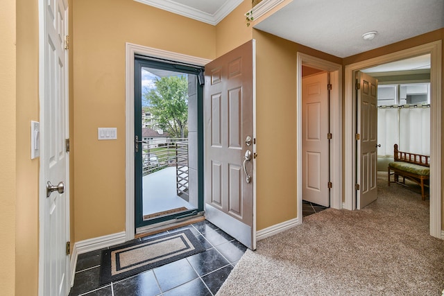 foyer entrance with ornamental molding and dark colored carpet