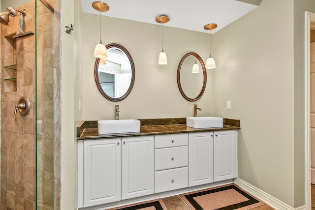 bathroom with tiled shower and vanity