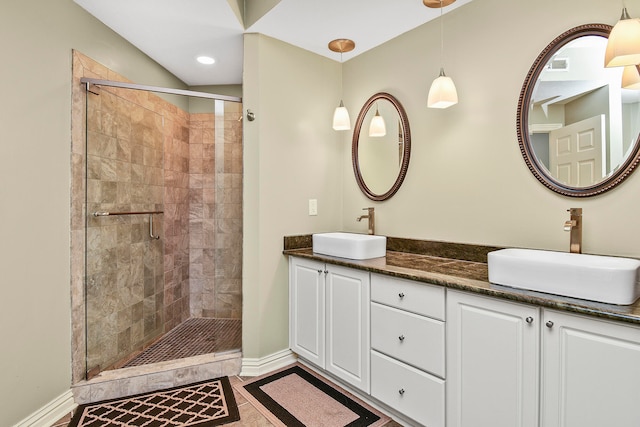 bathroom featuring tile patterned floors, walk in shower, and vanity