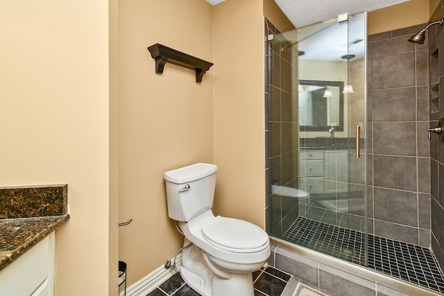 bathroom featuring tile patterned floors, vanity, walk in shower, and toilet