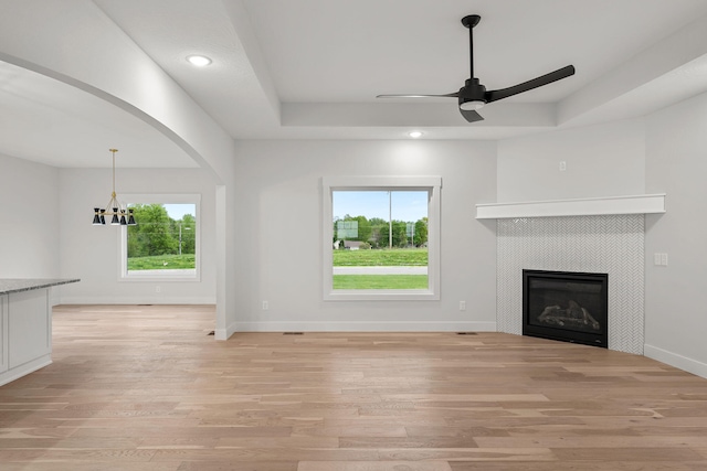 unfurnished living room with plenty of natural light, light wood-type flooring, and a tile fireplace