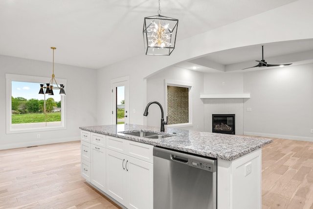 kitchen featuring an island with sink, pendant lighting, white cabinetry, and dishwasher