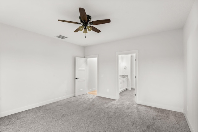 unfurnished bedroom with ceiling fan, light colored carpet, and connected bathroom