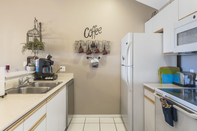 kitchen with light tile patterned flooring, white appliances, white cabinets, and sink