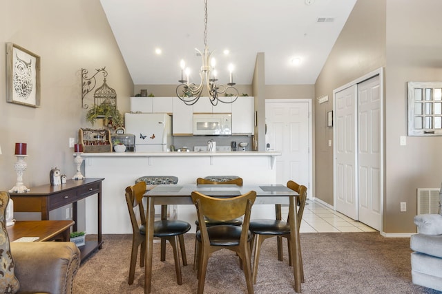 carpeted dining room with high vaulted ceiling and an inviting chandelier