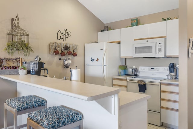 kitchen with white appliances, a breakfast bar, lofted ceiling, kitchen peninsula, and white cabinets