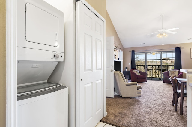 washroom featuring ceiling fan, stacked washer / dryer, and light carpet