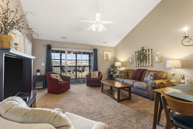 carpeted living room with ceiling fan and high vaulted ceiling