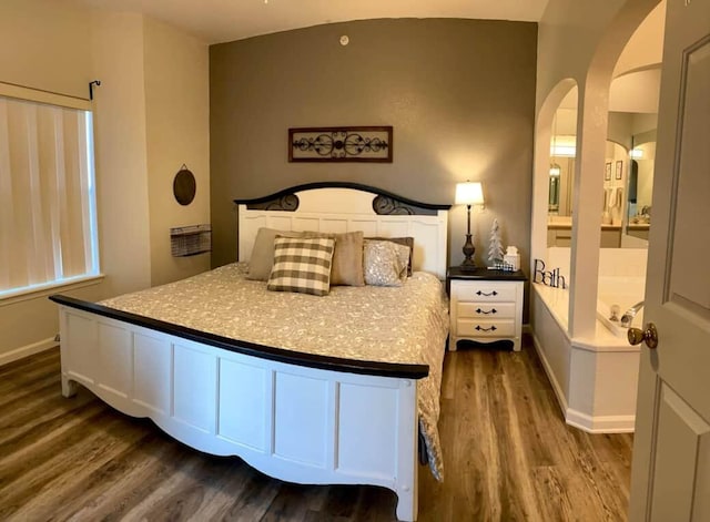 bedroom featuring ensuite bathroom and dark wood-type flooring