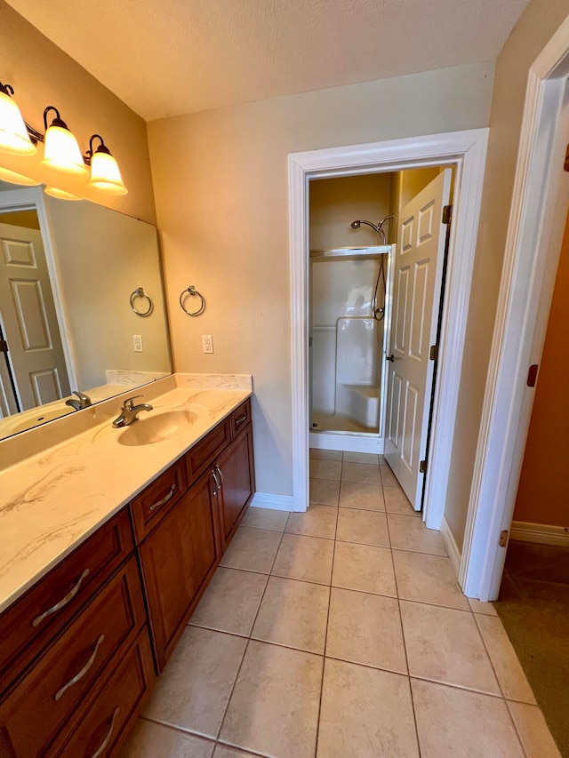 bathroom featuring tile patterned floors, vanity, a shower with shower door, and a textured ceiling