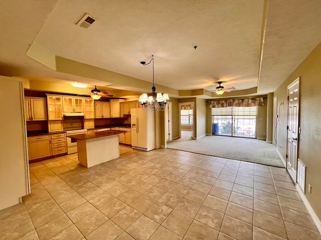 kitchen with pendant lighting, white appliances, a textured ceiling, light carpet, and ceiling fan with notable chandelier