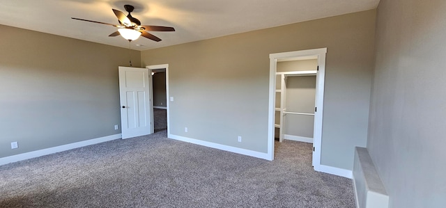 unfurnished bedroom featuring carpet, a closet, a spacious closet, and ceiling fan