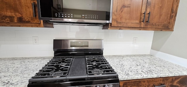 kitchen featuring light stone counters and black gas range oven