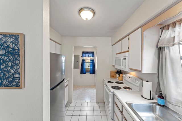 kitchen featuring electric panel, white appliances, sink, light tile patterned floors, and white cabinetry